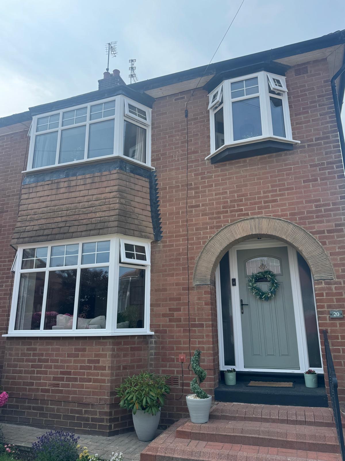 Semi-detached brick house with new white bay windows and a sage green composite front door