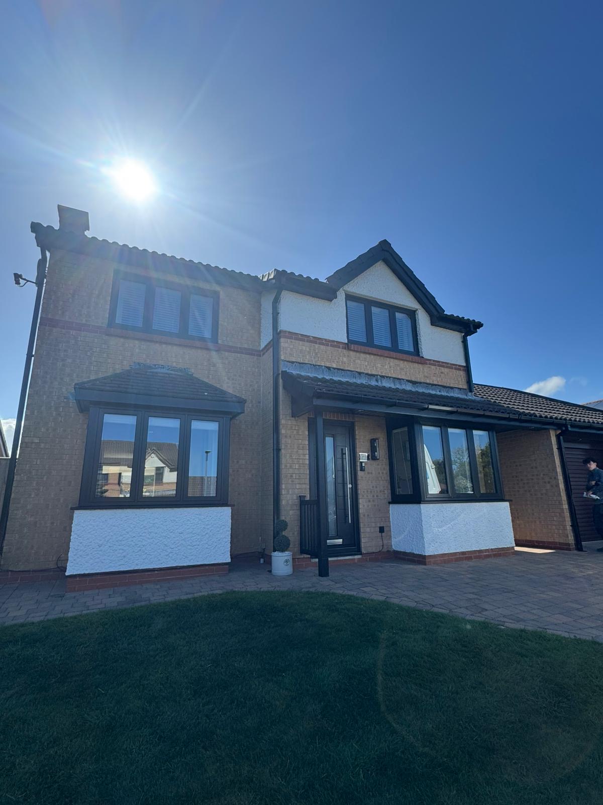 Detached house with new dark-framed windows across the front
